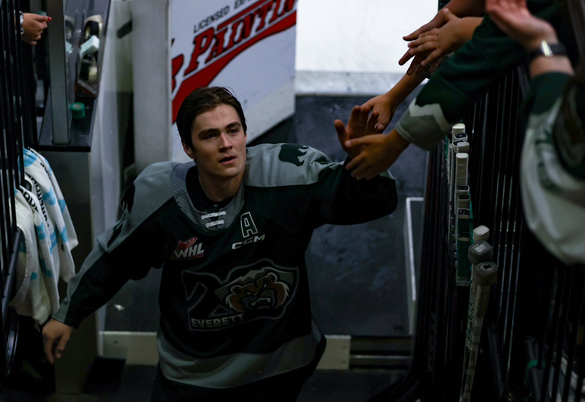Everett Silvertips forward Austin Roest high fives some fans as he exits the ice