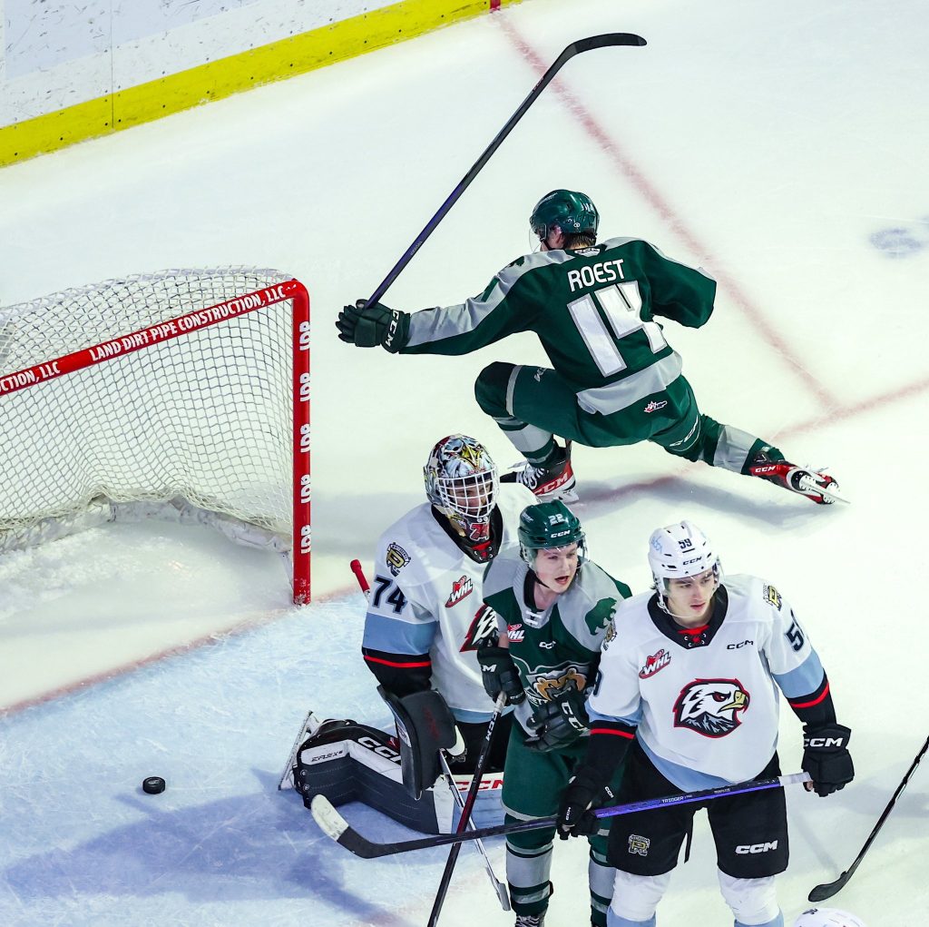 Austin Roest celebrates a goal on Portland Winterhawks goaltender Dante Giannuzzi. Everett Silvertips forward Jesse Heslop and Portland defenseman Carter Sotheran also shown