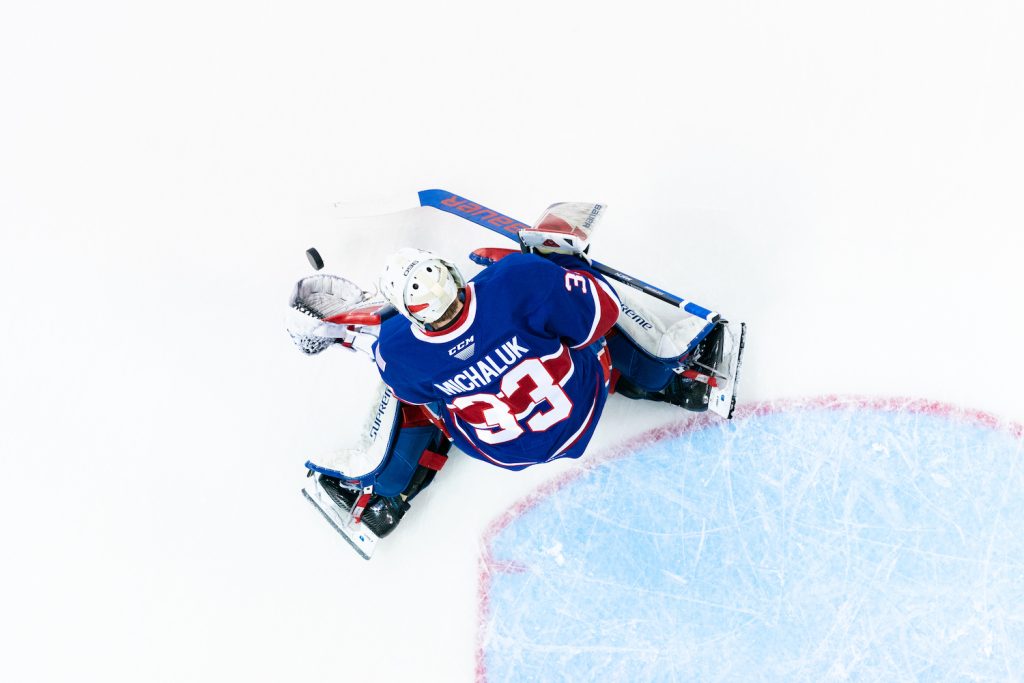 Goaltender Cooper Michaluk makes a save, as seen from an overhead view.