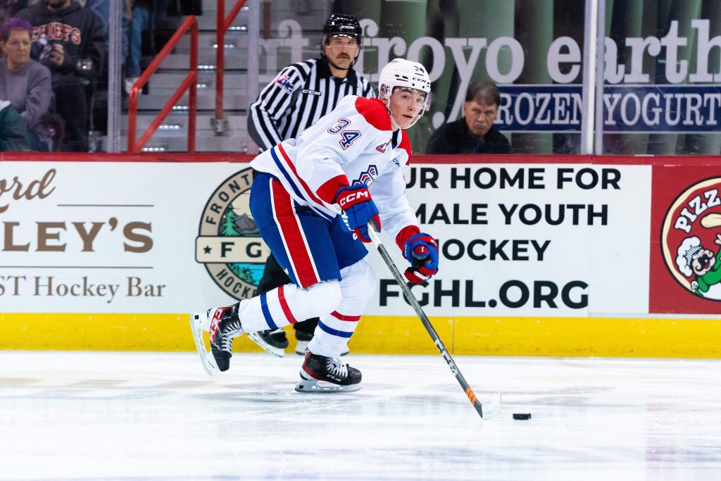 An action shot of Conner Roulette on the ice. He has on the Chiefs' white uniform.