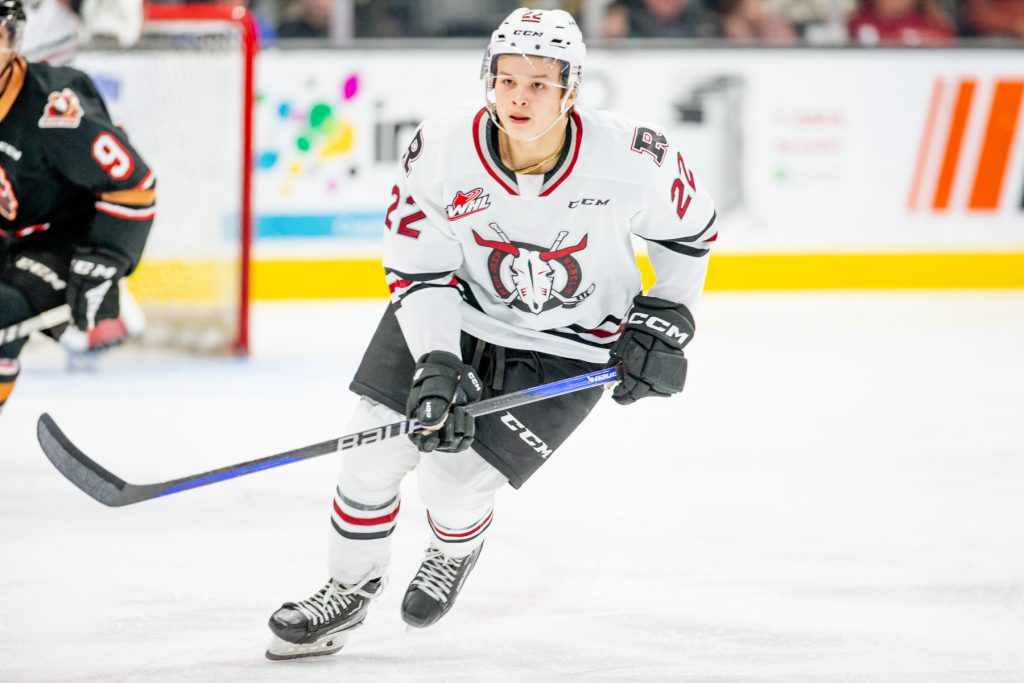 An action shot of Dwayne Jean Jr. on the ice in a Rebels uniform.