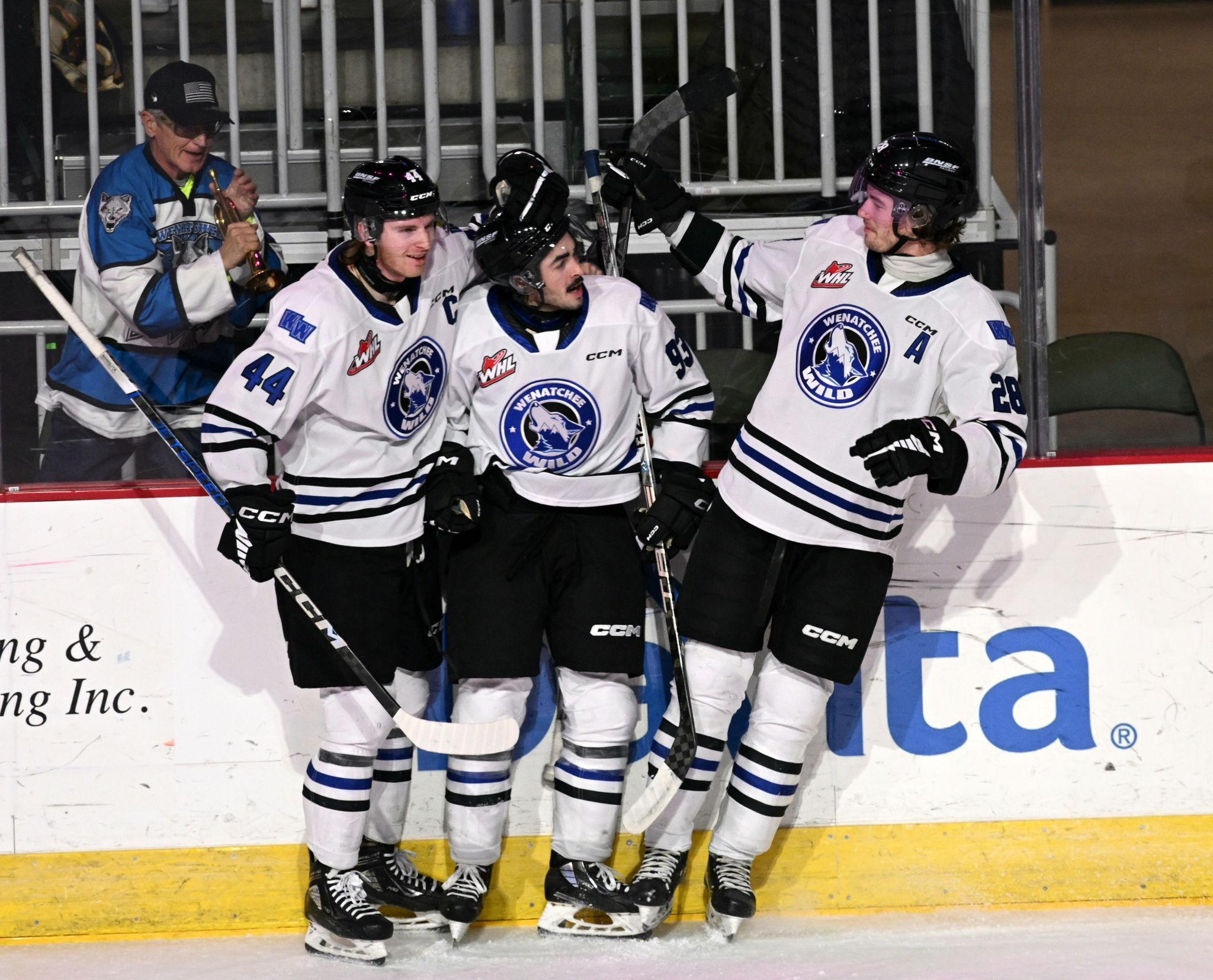 Graham Sward, Matthew Savoie, and Conor Geekie celebrate a goal on the ice.